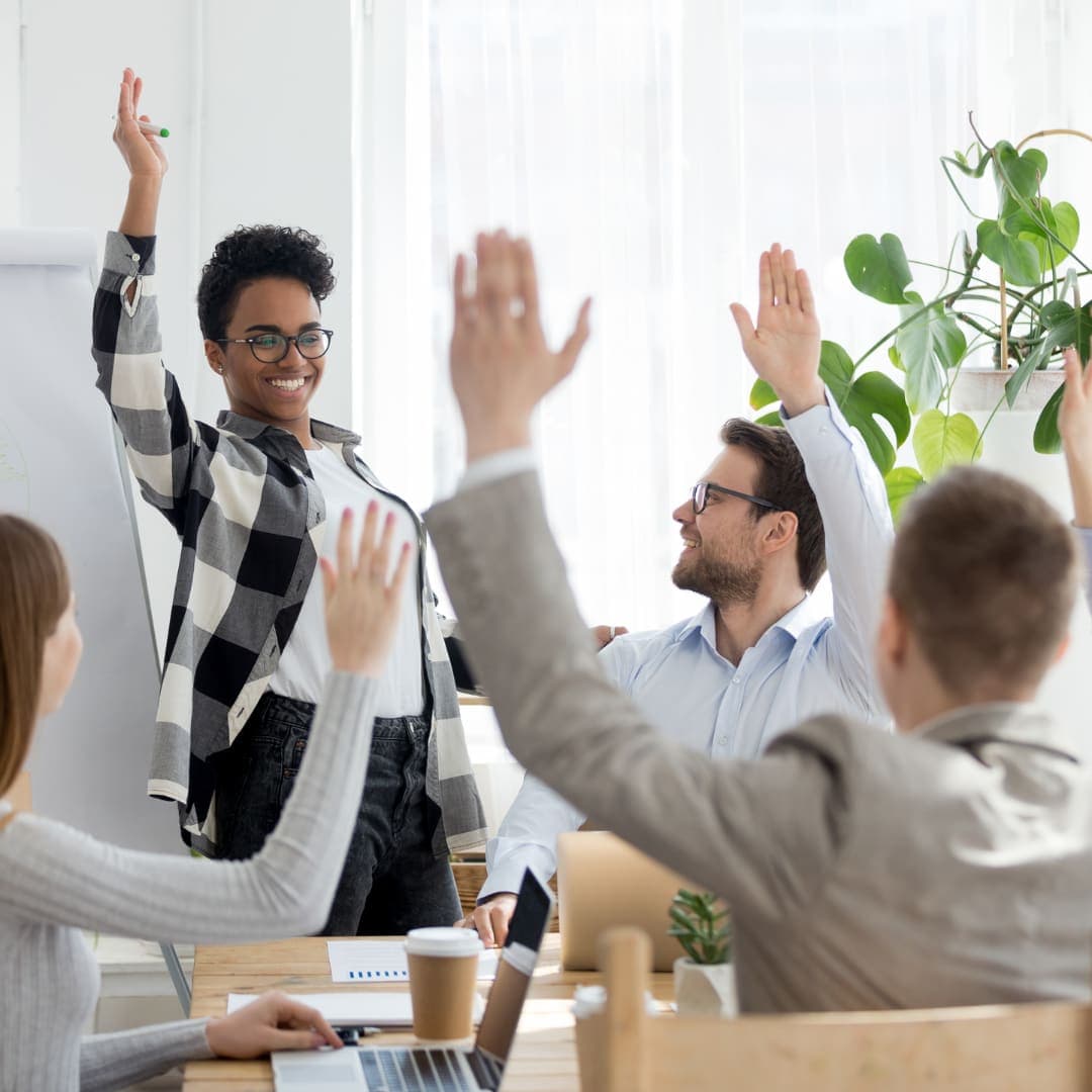 Workshop participants raising their hands during a community session