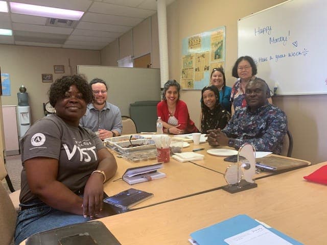 CDR staff and AmeriCorps VISTA members meeting around a conference table