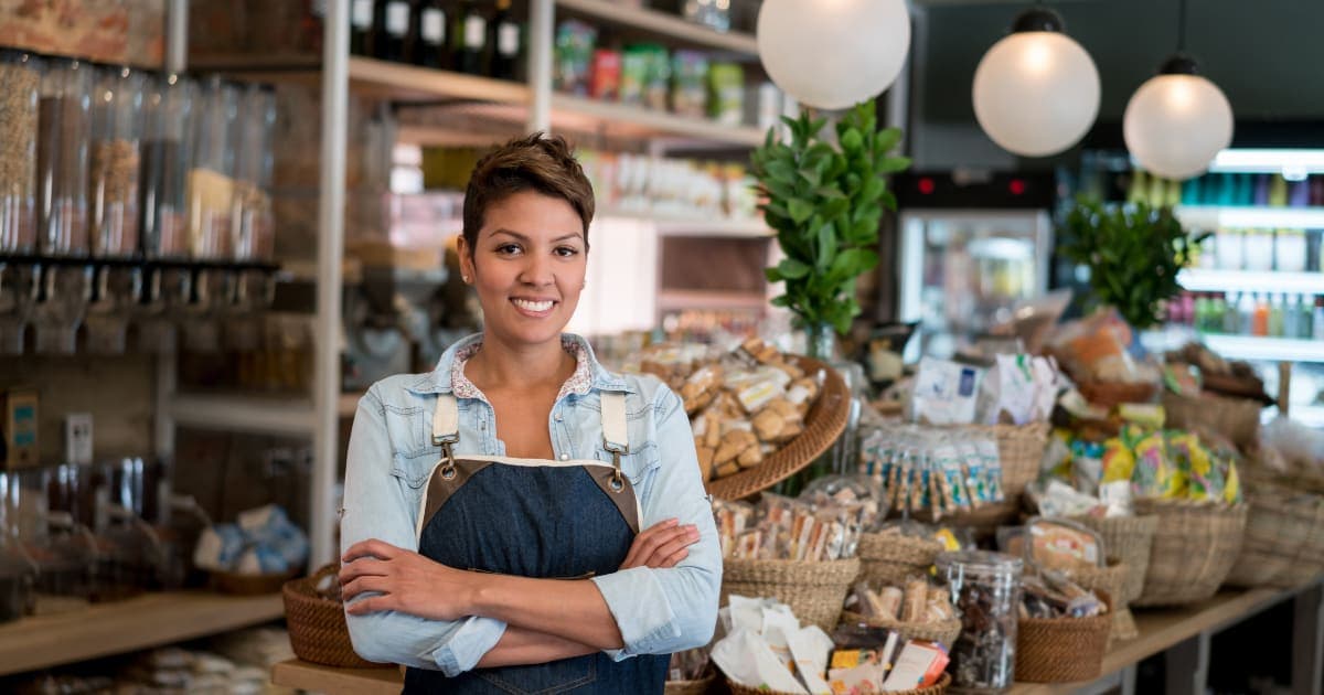 Small business owner standing proudly in her grocery store